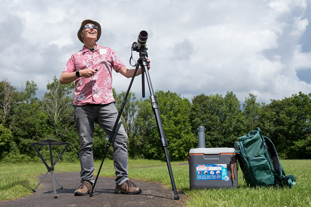 Photographer with tripod and camera prepared for the solar eclipse