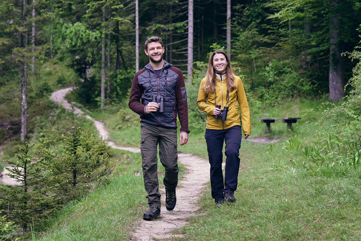 Couple out walking on forest path enjoying nature with ZEISS Conquest HDX binoculars