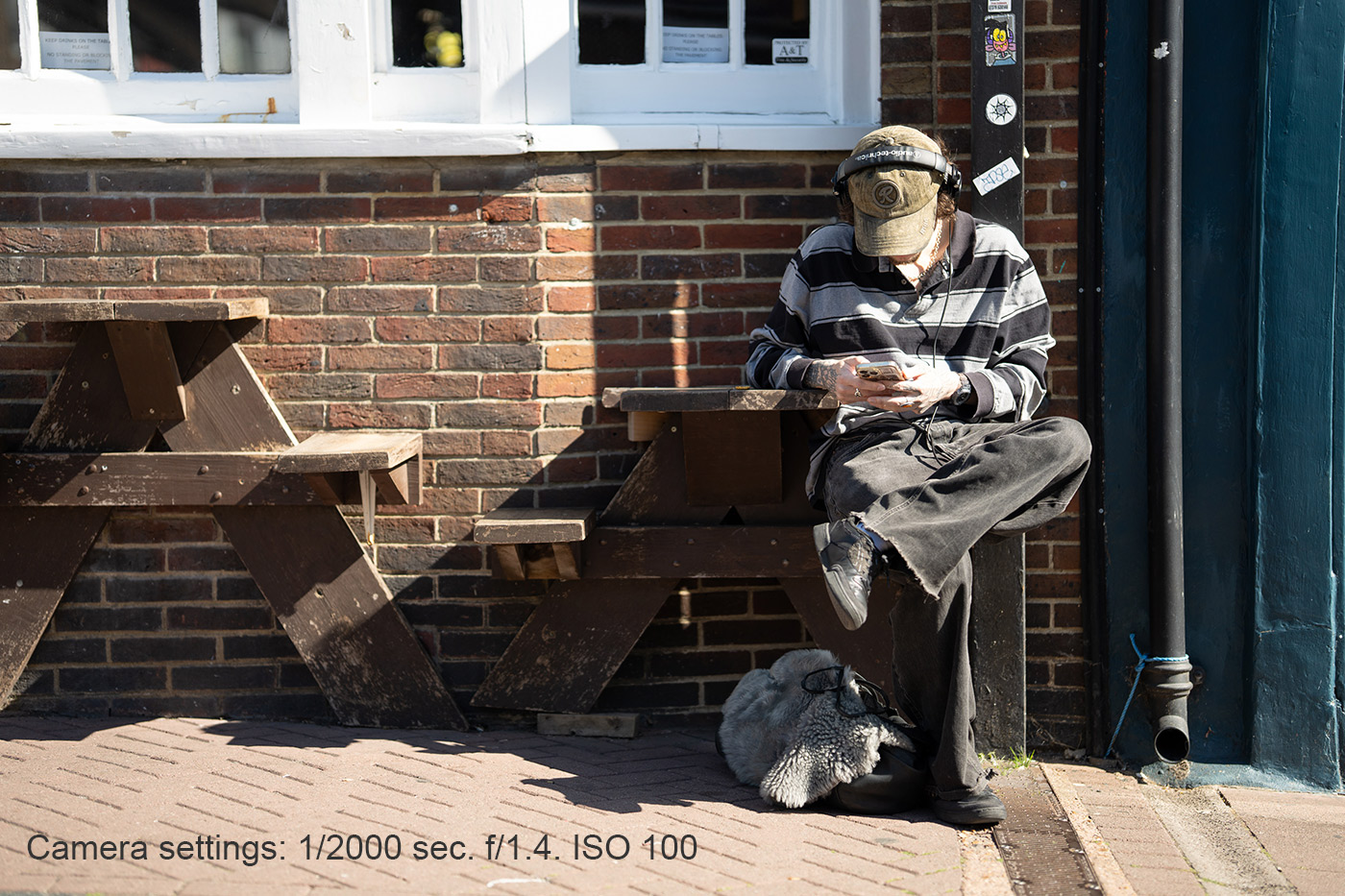 Sample 10 Street Texting Portrait. Camera settings: 1/2000 sec. f/1.4. ISO 100