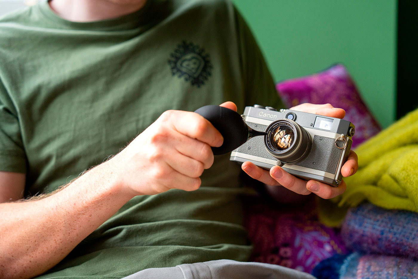 Blowing dust off lens with a blower