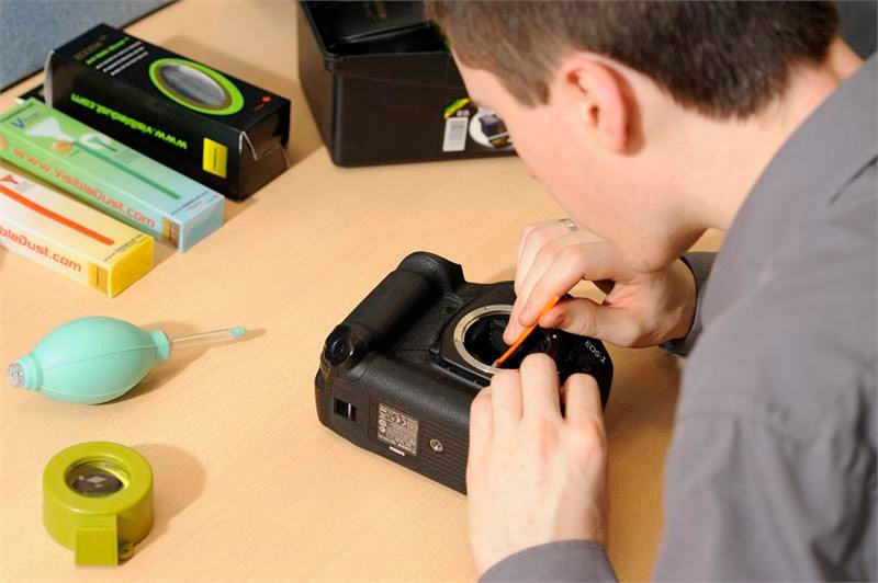 Professional tech cleaning a camera sensor