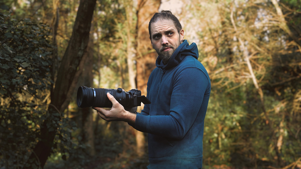 Gareth photographing in the forest with the OM System super telephoto lens