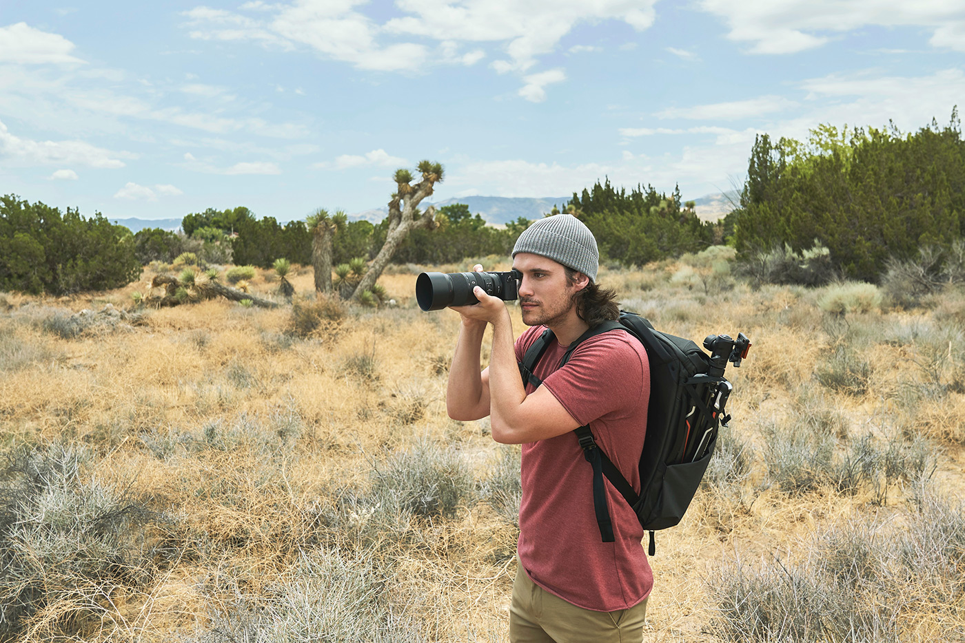 Photo of young person using SOny camera in the desert while travelling to capture video