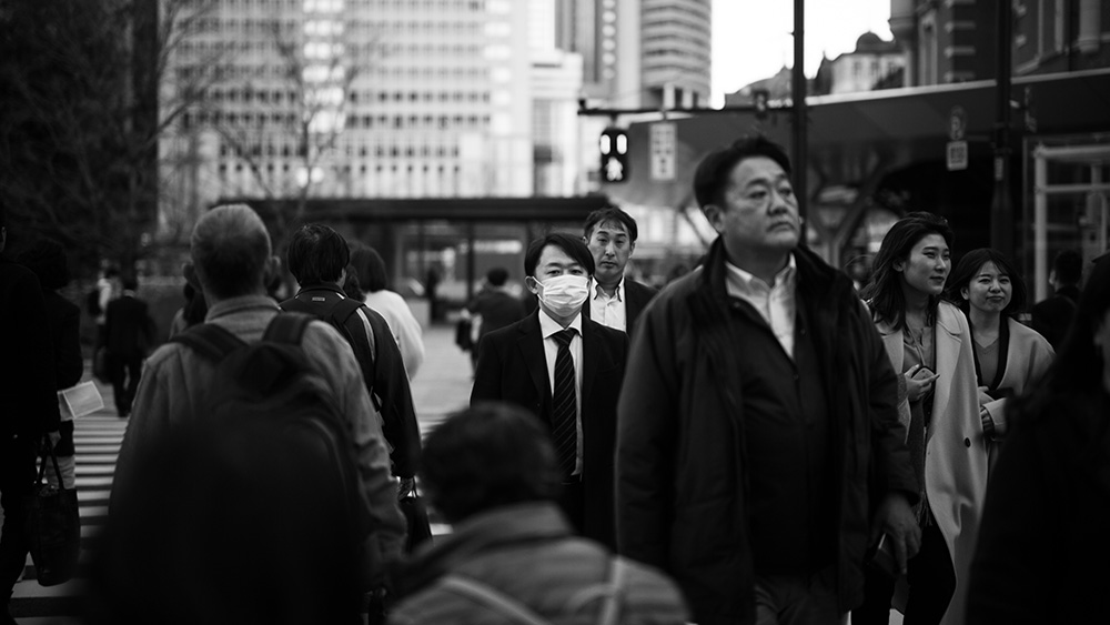 Crowd in Japan with mask wearer highlighting composition